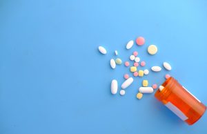 FDA Approves Capivasertib Pill for Common Breast Cancer A healthcare professional holds a bottle of Truqap pills beside a patient in a clinic exam room.