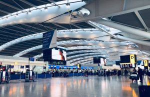 Delhi Airport Roof Collapse Kills 1, Injures 8 Crowded terminal at Indira Gandhi International Airport with a collapsed roof section and debris scattered on the floor.