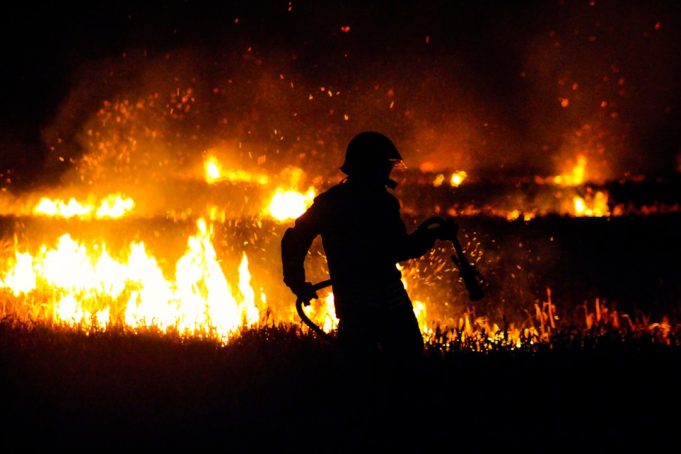 Smoldering sagebrush and grassland north of Gillette under a smoke-filled sky after a fatal plane crash sparked a wildfire.