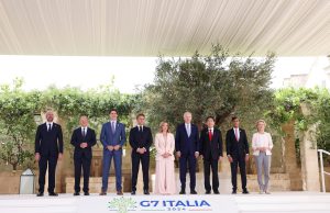 G7 Leaders Gather for 50th Summit in Italy World leaders seated at a conference table during the 50th G7 summit in Fasano, Italy, with flags of member nations in the background.