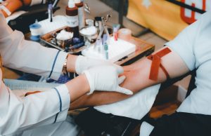 FDA Approves Lyfgenia Gene Therapy for Sickle Cell A scientist examines a vial of Lyfgenia gene therapy in a laboratory, with DNA helix graphics in the background.